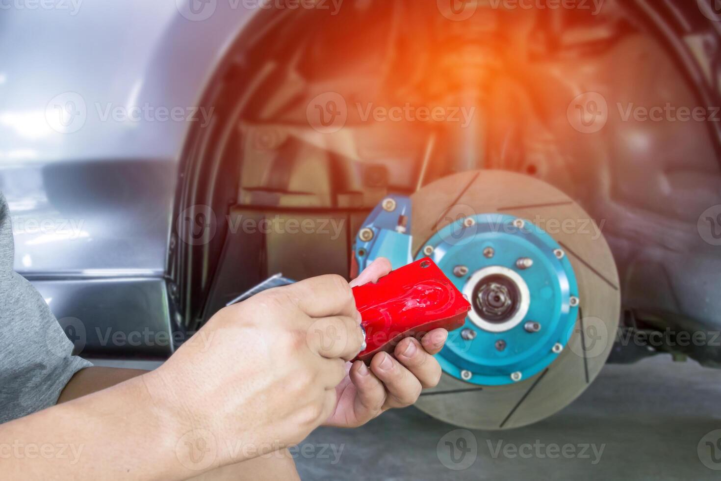 Hand Technician apply grease on new brake pad and change in caliper with car wheel basic service