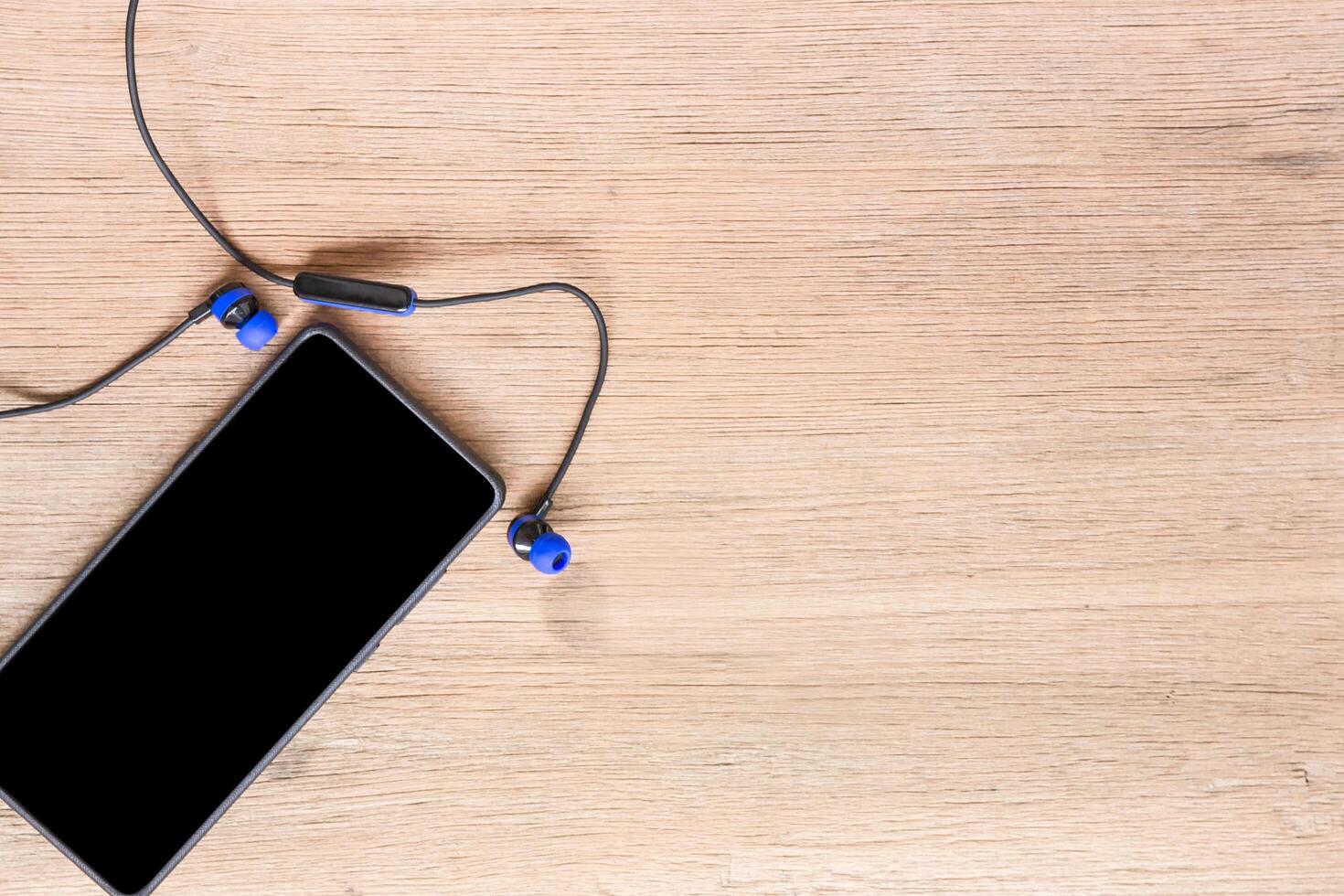 Smart phone and bluetooth headset on wood floor background healthcare and relax concept photo