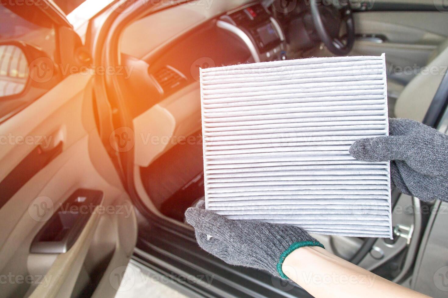 Close up Air filter in hand service concept in air condition system of car and inside car blur background photo