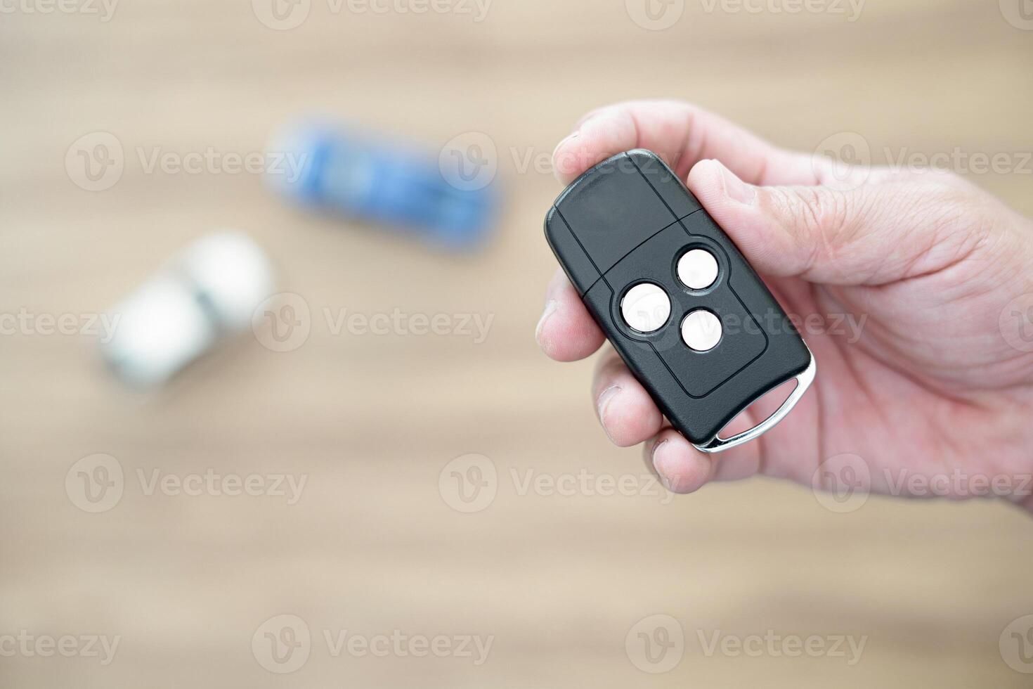 Key Car in hand a man for unlock and lock door a car with toy car in background photo