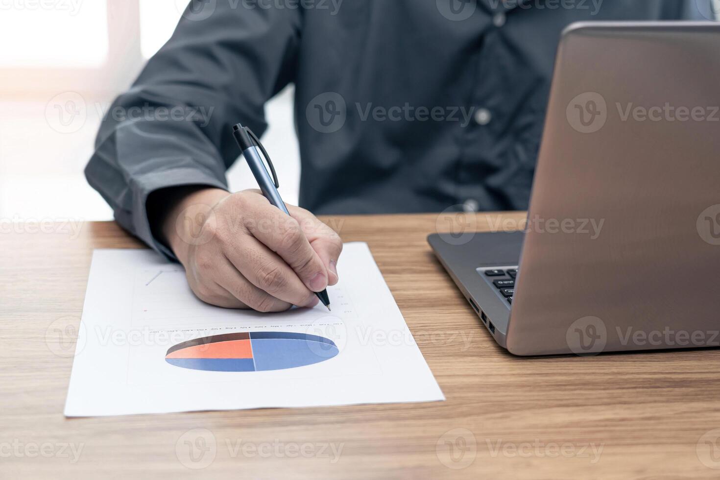 Business man working and analyzing on document data graph with laptop computer calculate for new project of business strategy at workplace. photo