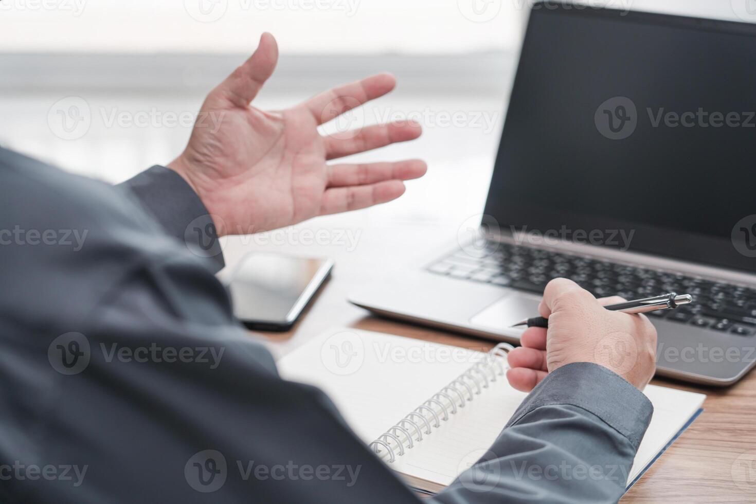 Action working concept  Business man use laptop computer and a pen write memo on note book paper work in office photo