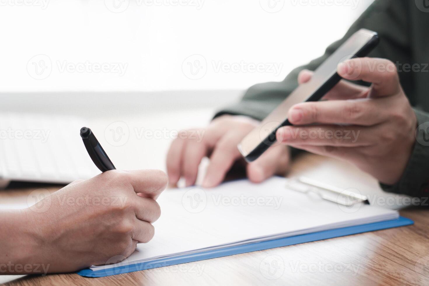 Close up hand women sign on insurance document for payment of car insurance and a man show display of smartphone for data Information about insurance photo