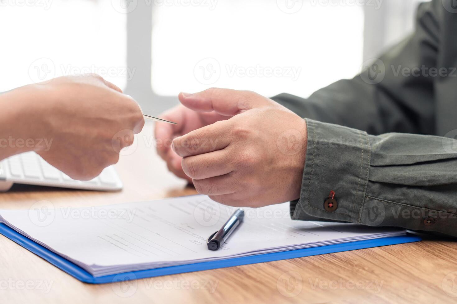 Man accepting credit card from women for payment of car insurance with the officials are introducing details in the smartphone  work in office concept photo