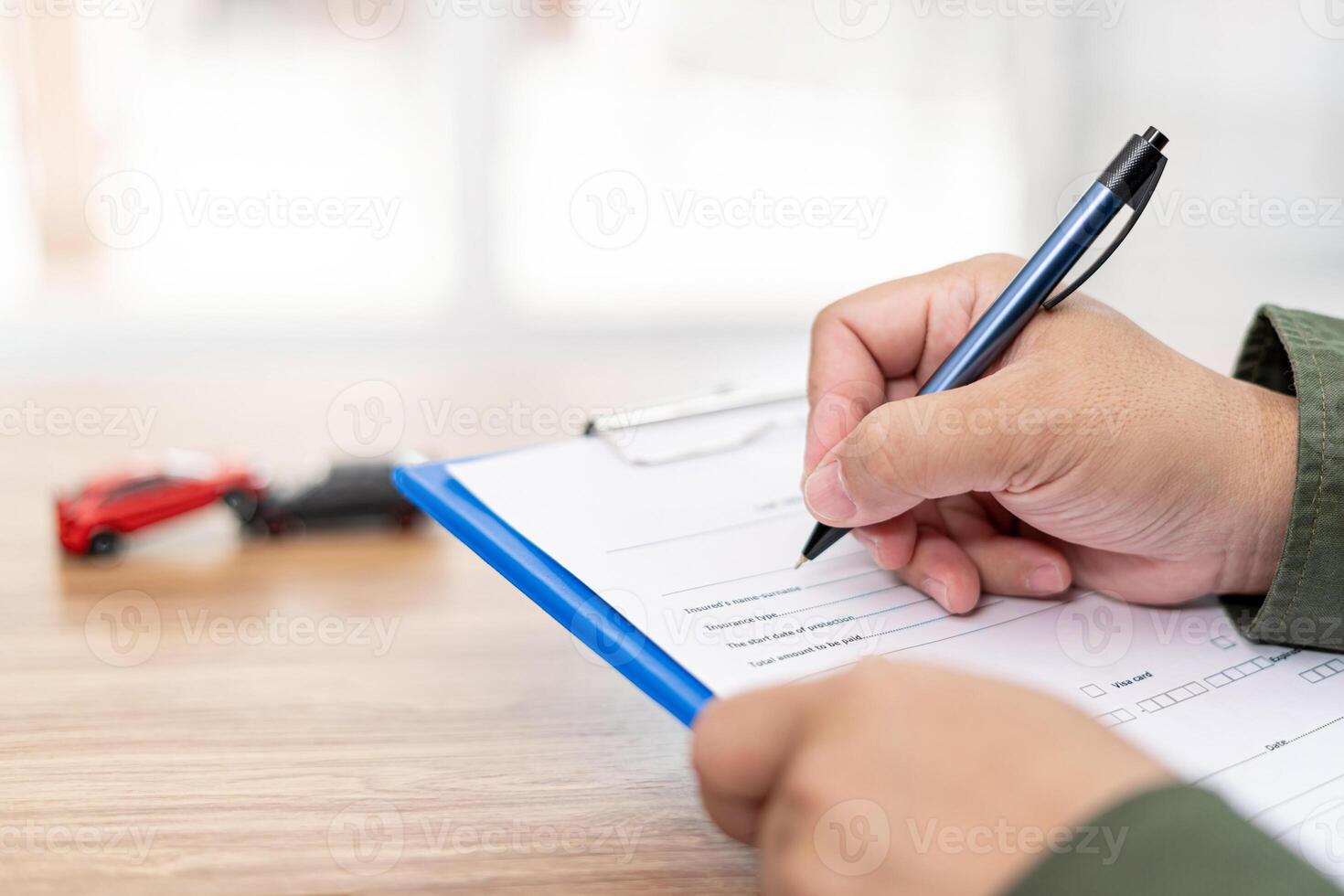 Accident concept of car  The officer write on record check sheet of car accident about the damage of the car collision and Toy car in background photo