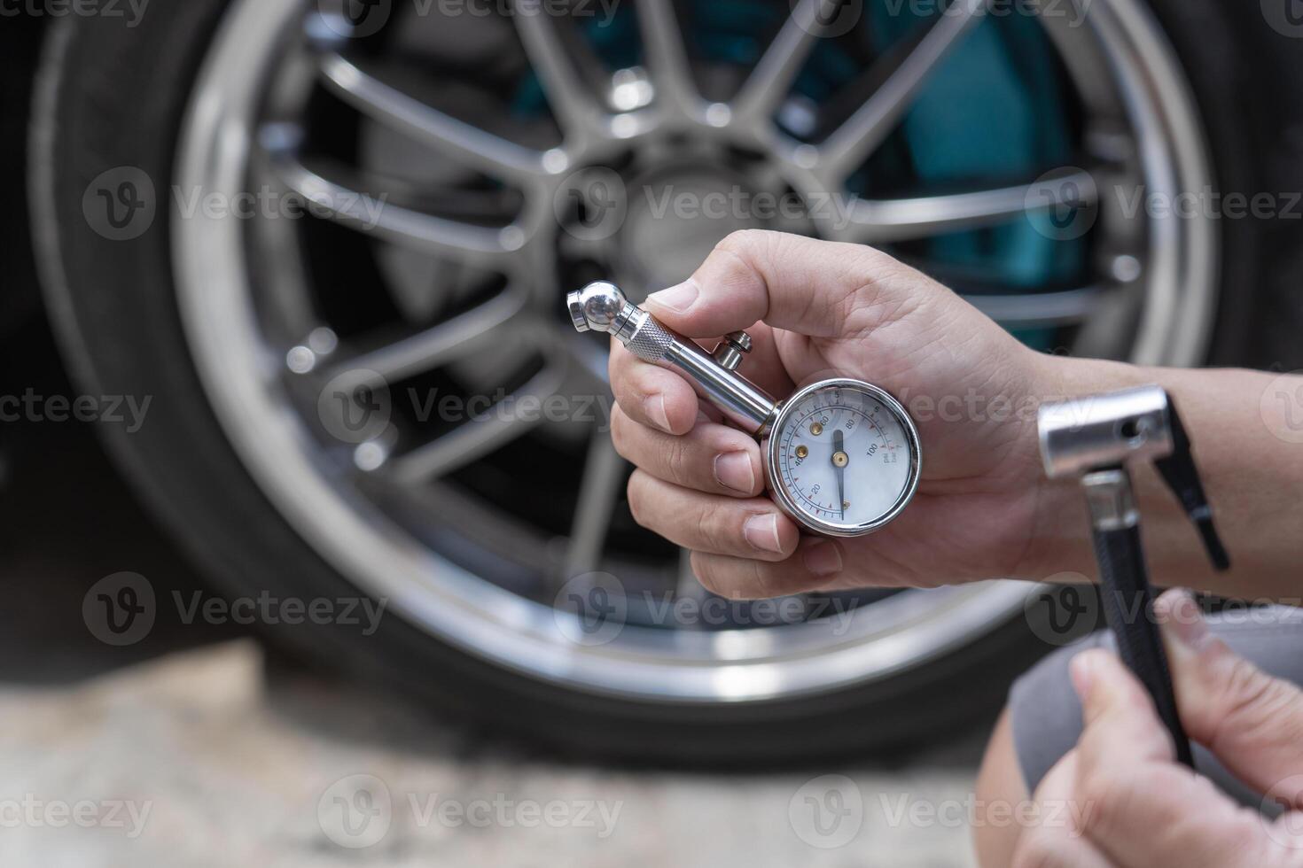 Home car basic check A man use air pressure gauge check tire air pressure and hole air hose for add air of tire photo
