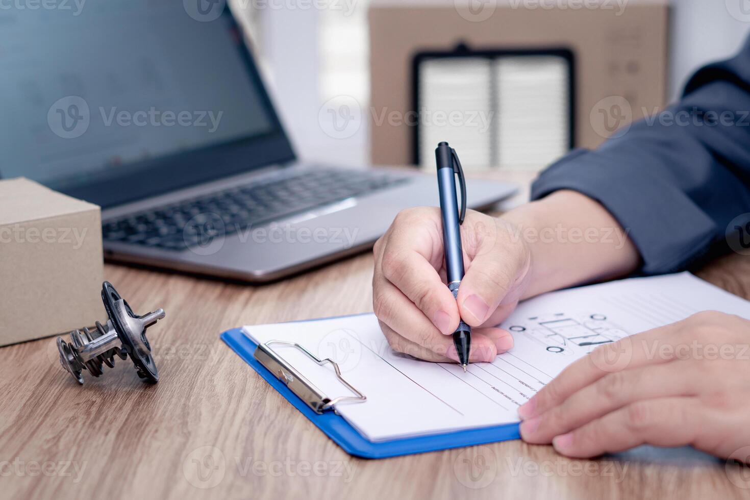 Car service staff write on the white paper clip file board part list and stock check with car thermostat of engine car air engine filter on table accuracy before replacing in periodic maintenance photo