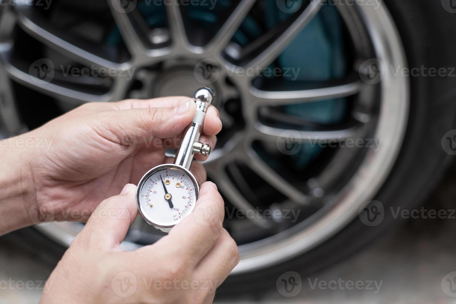 Home car basic check  close up A man hold air pressure gauge check tire air pressure in service concept photo