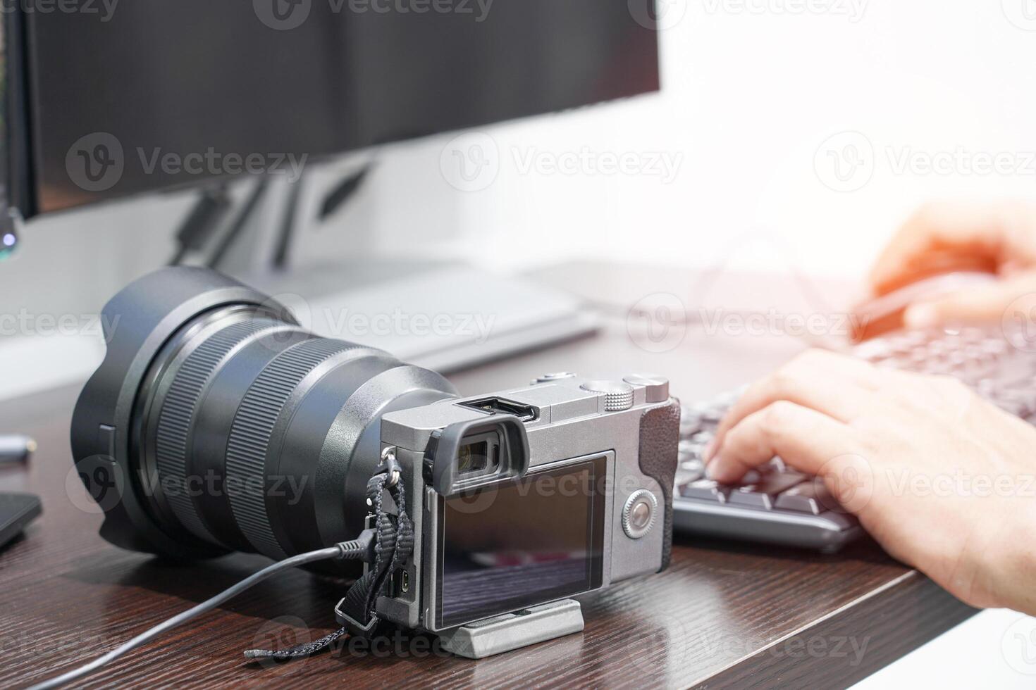 Business concept photo of Camera and photographer is working from his camera with computer in home