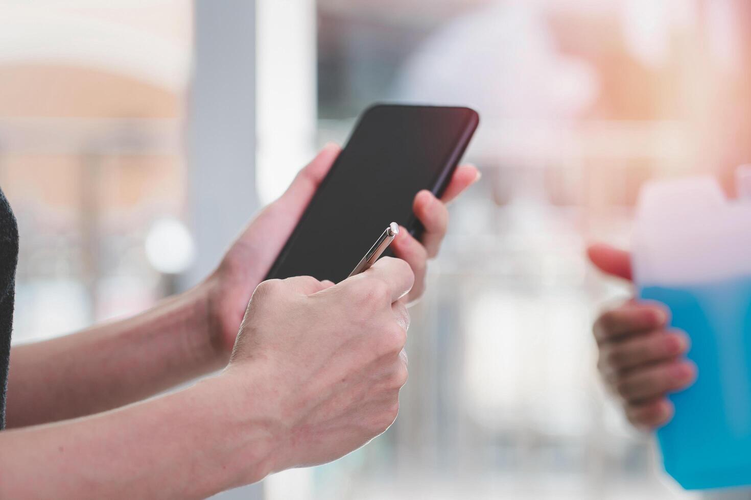 Women use electronic pen check and write on smartphone after check pick up package from the post office transport stay at home concept photo