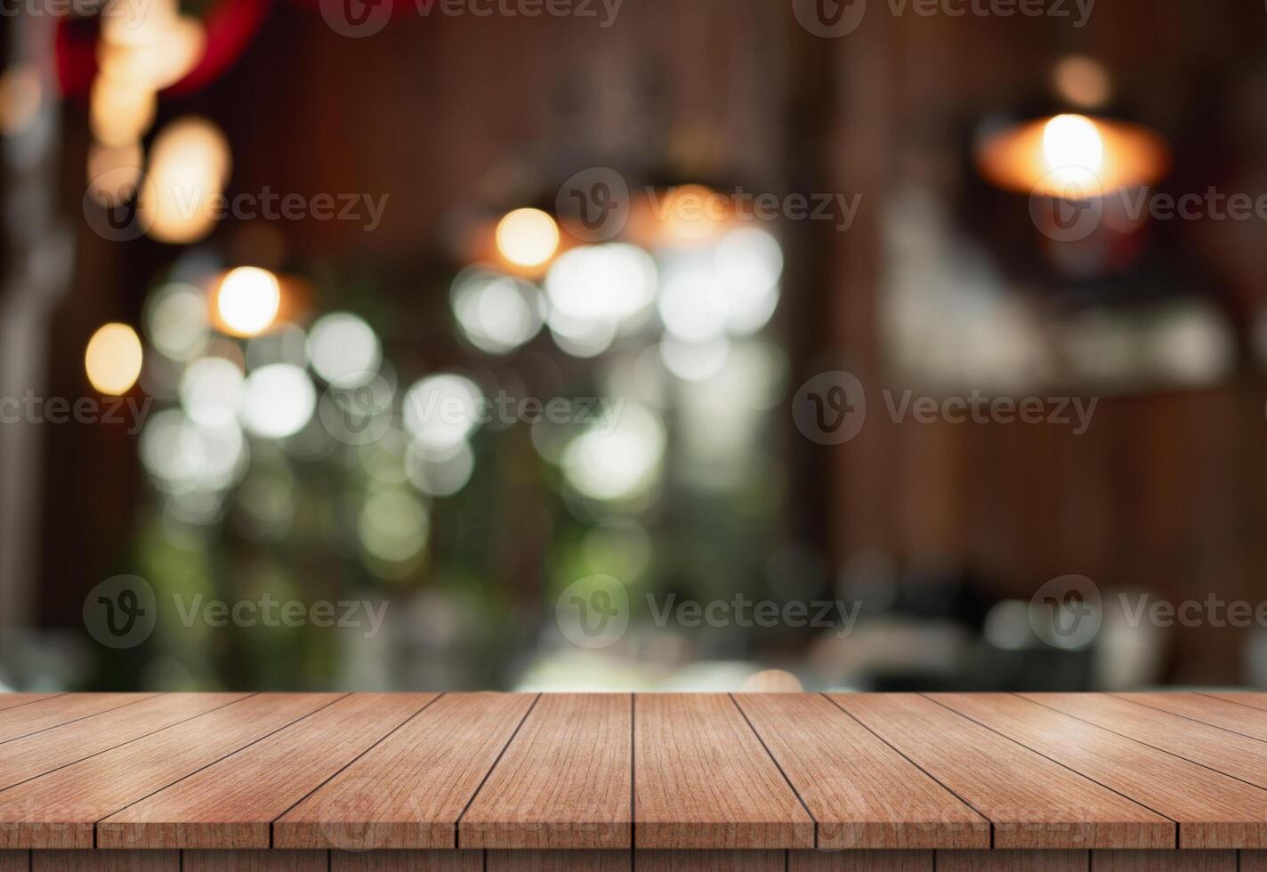 Empty wooden table top with lights bokeh on blur restaurant background. photo