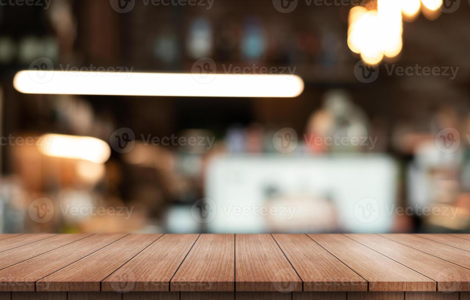 Empty wooden table top with lights bokeh on blur restaurant background. photo