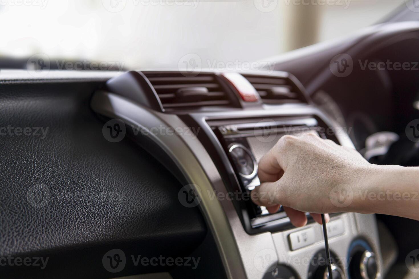 mano un hombre enchufe en USB cable en el coche audio utilizar conectando datos coche jugar y música navegación sistema en el coche. foto