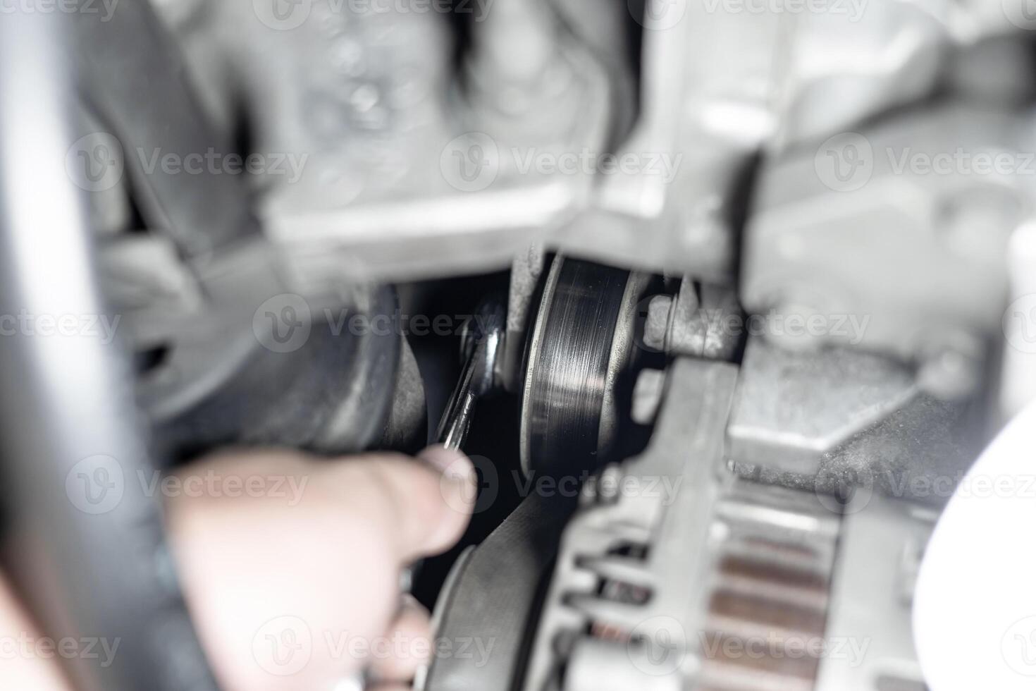 Belt Tension Pulley  of car engine and a man use wrench adjust and Replacement of spare parts in engine room photo