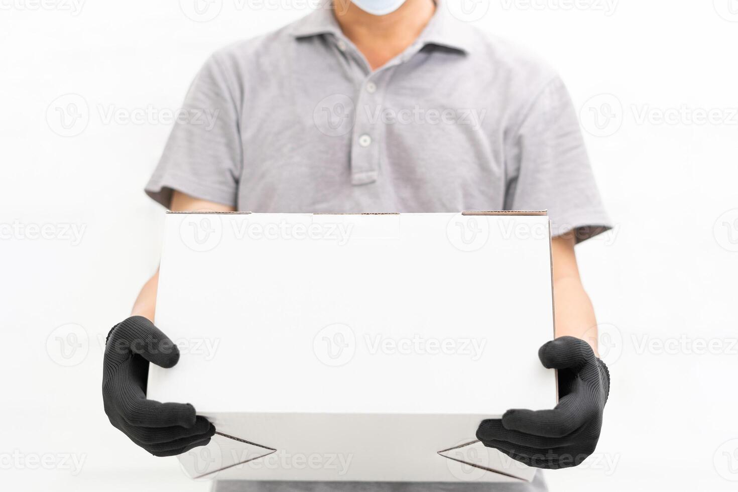 Man use hand to lift the shopping box wearing gloves and protective mask for protection in delivery work with white cement wall background photo