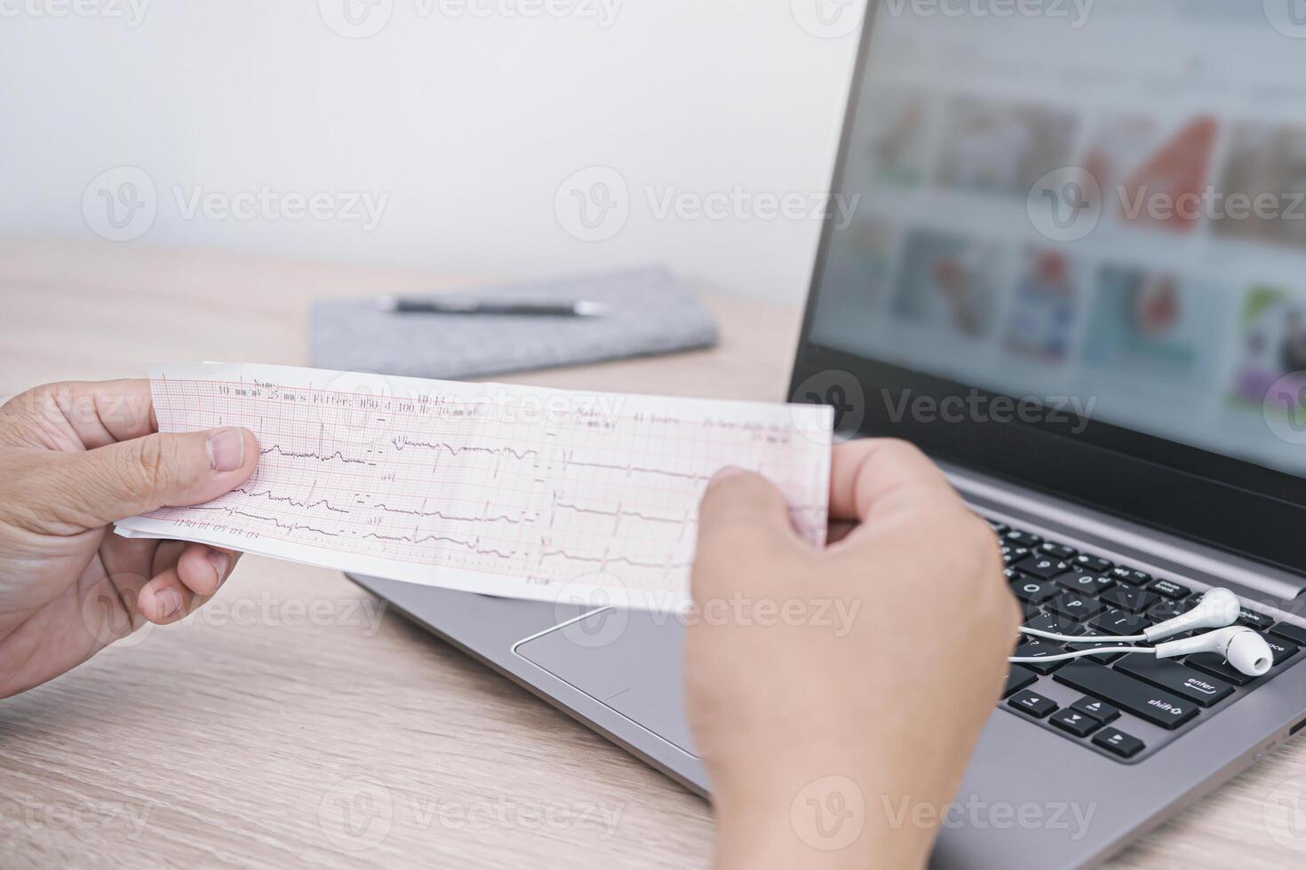 cerca arriba corazón Velocidad resultado grafico papel documento electrocardiograma en mano un hombre análisis de médico investigación resultados y ordenador portátil computadora en antecedentes foto