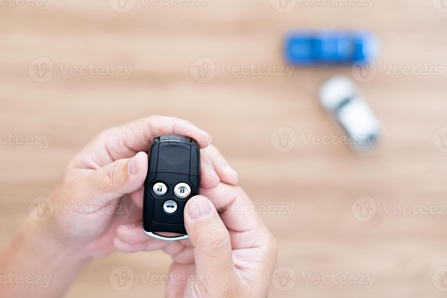Close up hand of man holding remote control for lock and Un-lock car concept model toy a car in blur background photo