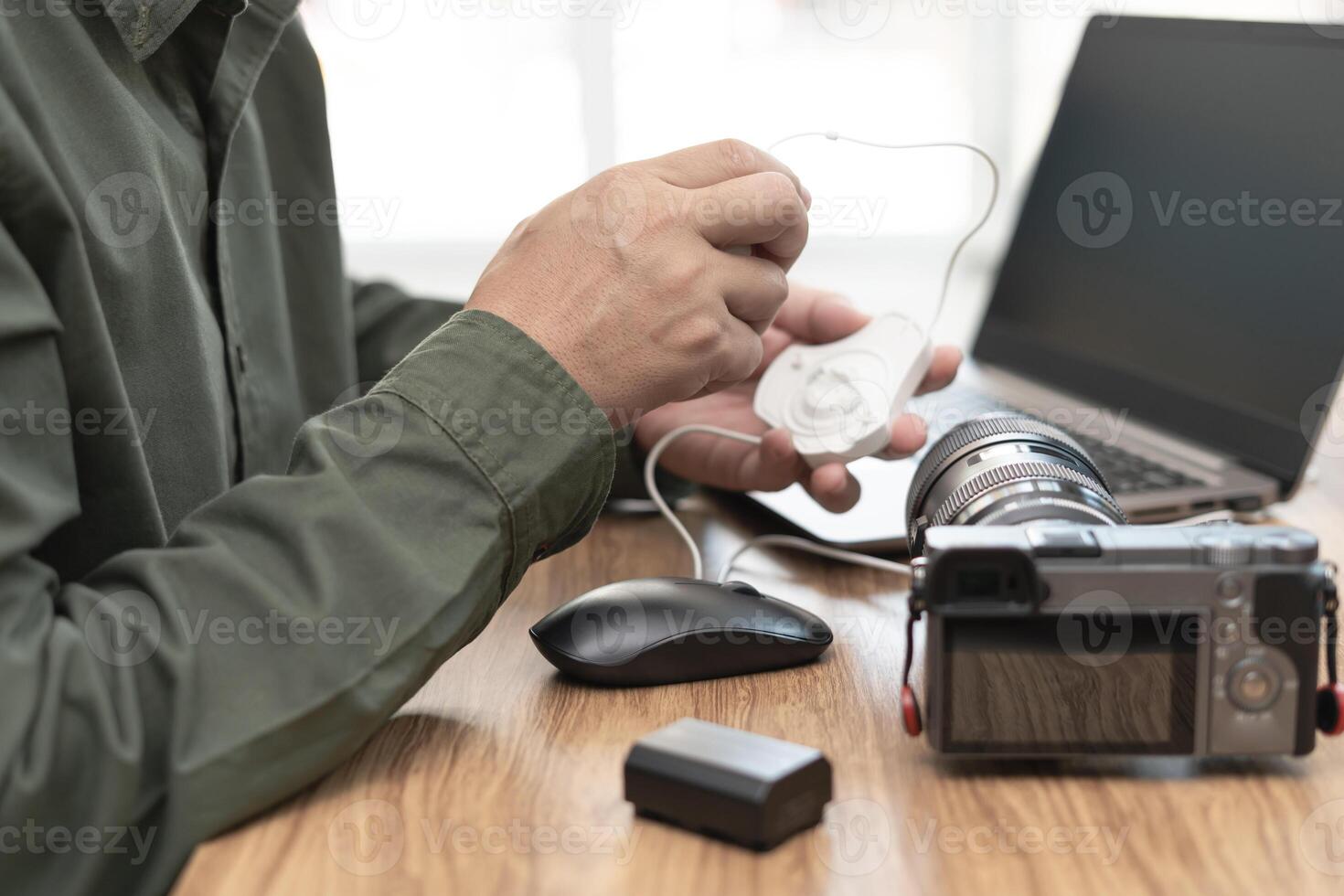 Close up hand man use color Calibration machine on monitor laptop photographer computer for Display Calibration and camera ,battery on the wood table photo