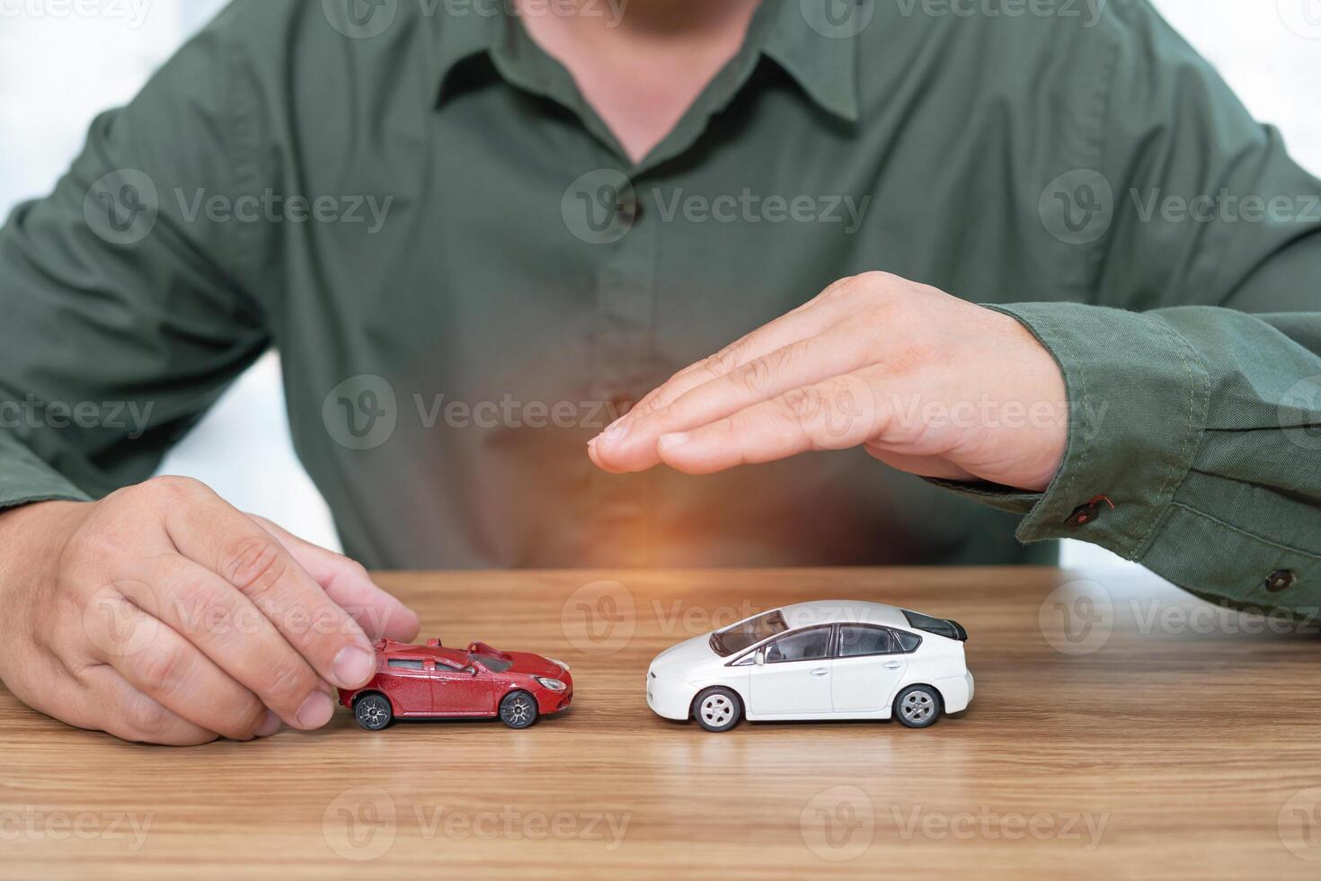 Comparisons of the accident concept in use car A man with toy car perfect condition in and compare the damaged toy cars on wood table photo