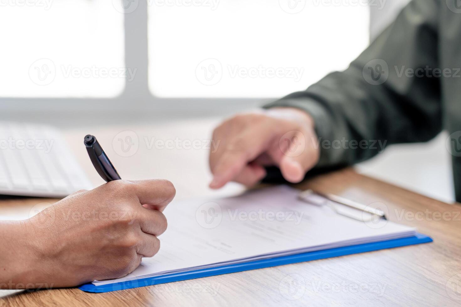Close up hand women sign on insurance document for payment of car insurance with the officials are introducing details in the insurance documents work in office photo