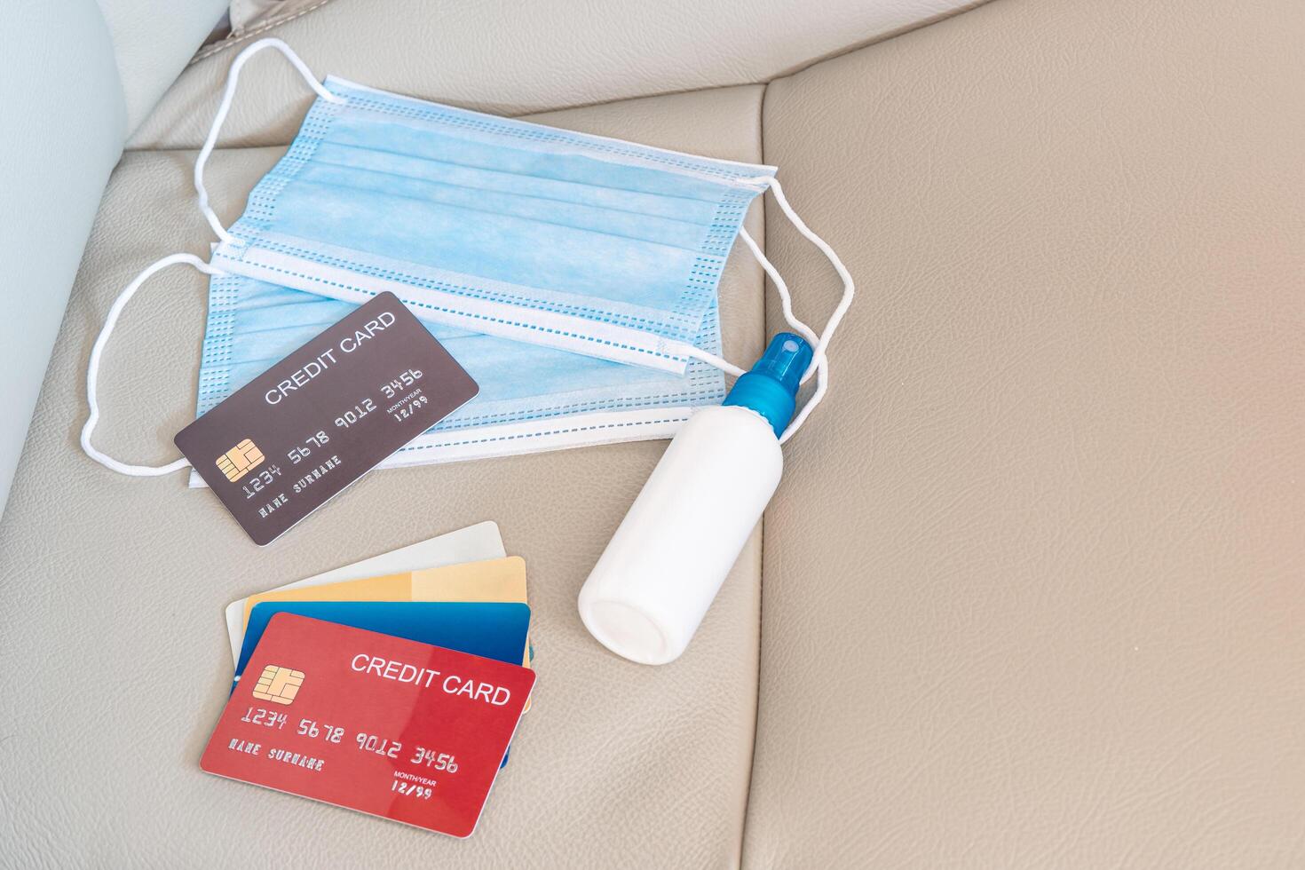 Cleaning concept Alcohol spray mask and credit card are placed on the car seat basic antivirus protection equipment In car use everyday photo