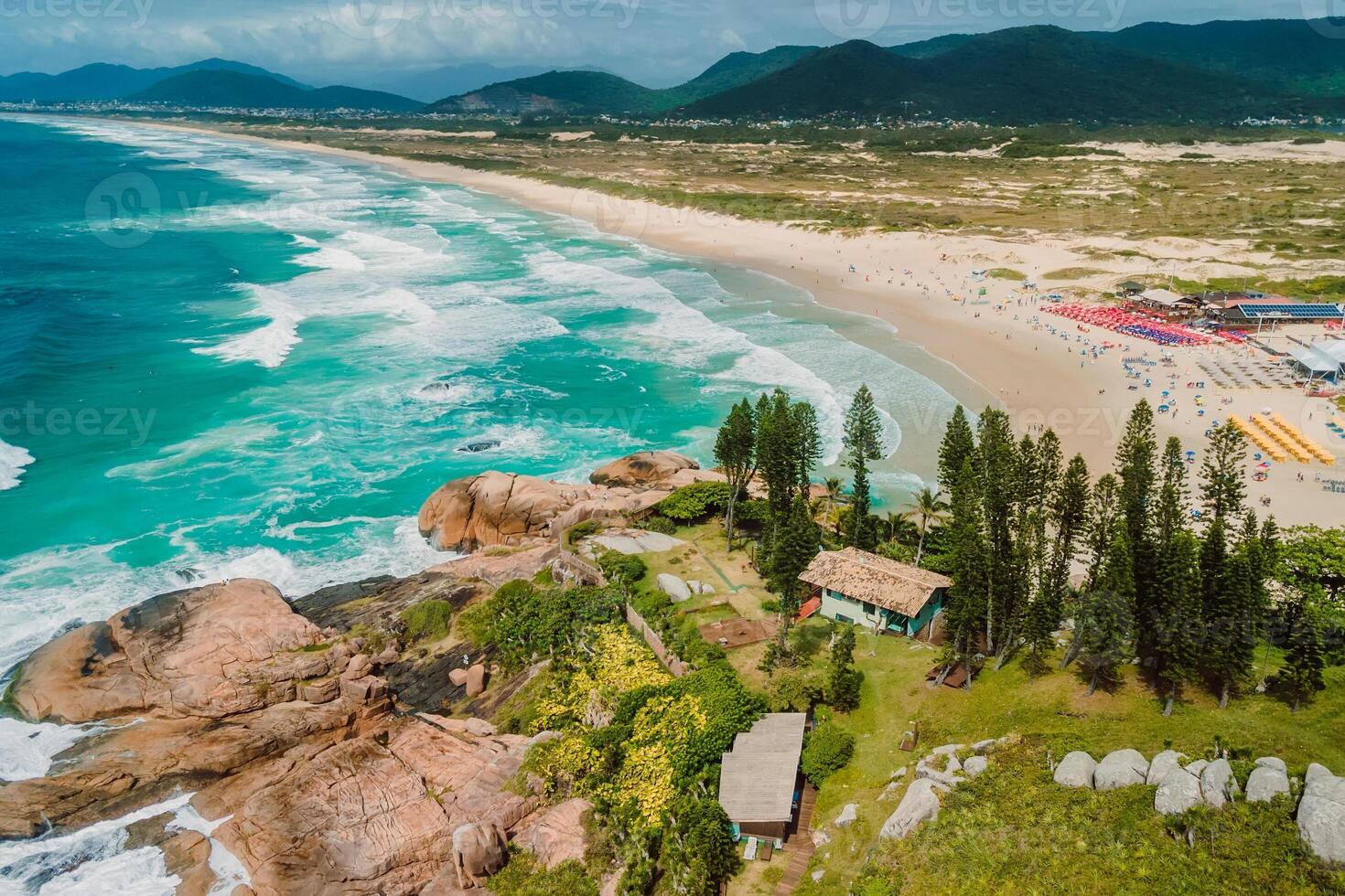 Popular holiday beach with trees and ocean with waves in Brazil. Aerial view of coastline photo