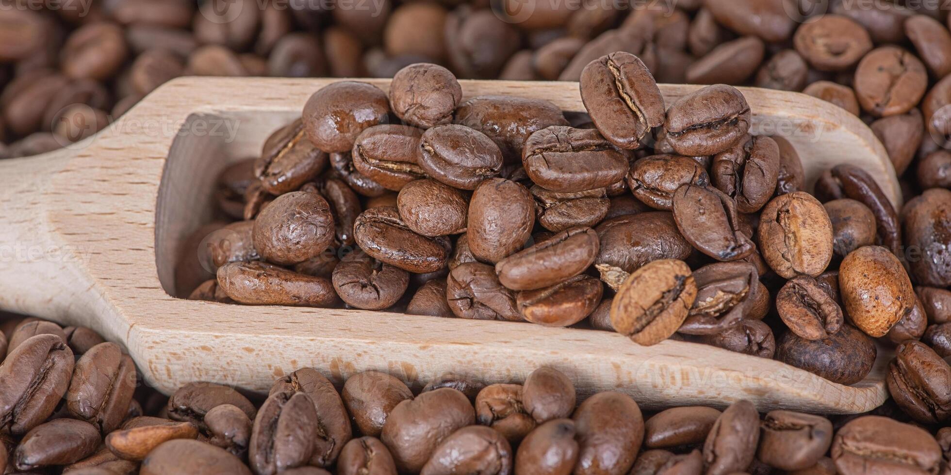 Wooden spoon with coffee and coffee beans on the background. Coffee as background. photo