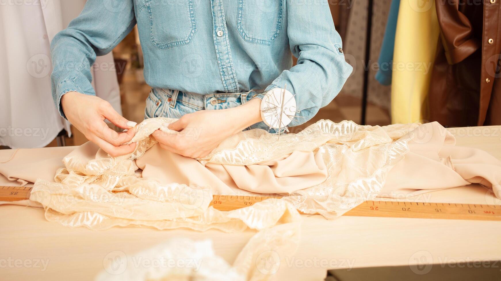 portrait of seamstress, woman in process of work, sewing studio, holiday, seamstress day, light industry. Hands. photo