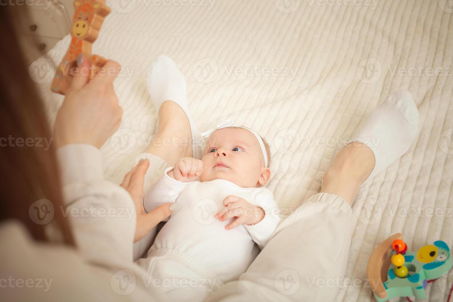 mother plays with newborn baby photo