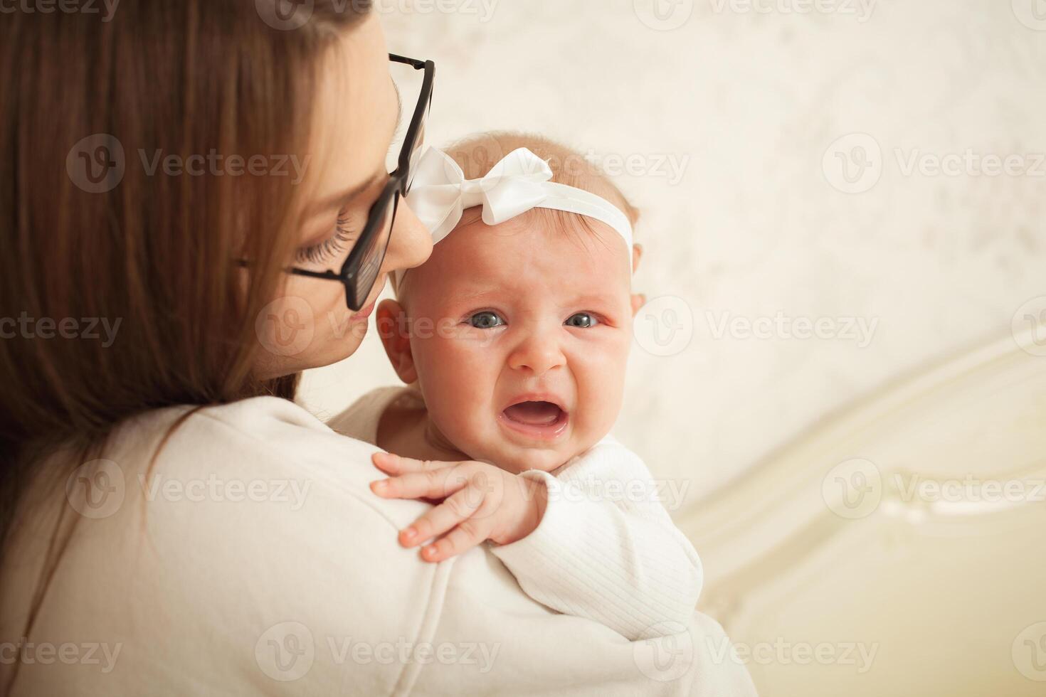 mother plays with newborn baby photo