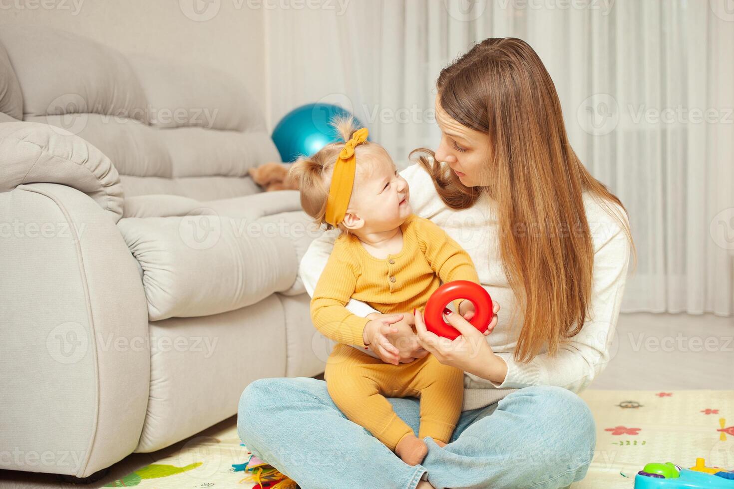 Mother and daughter play together, learn, home room, fun, love and care. A one year old girl. Funny. photo