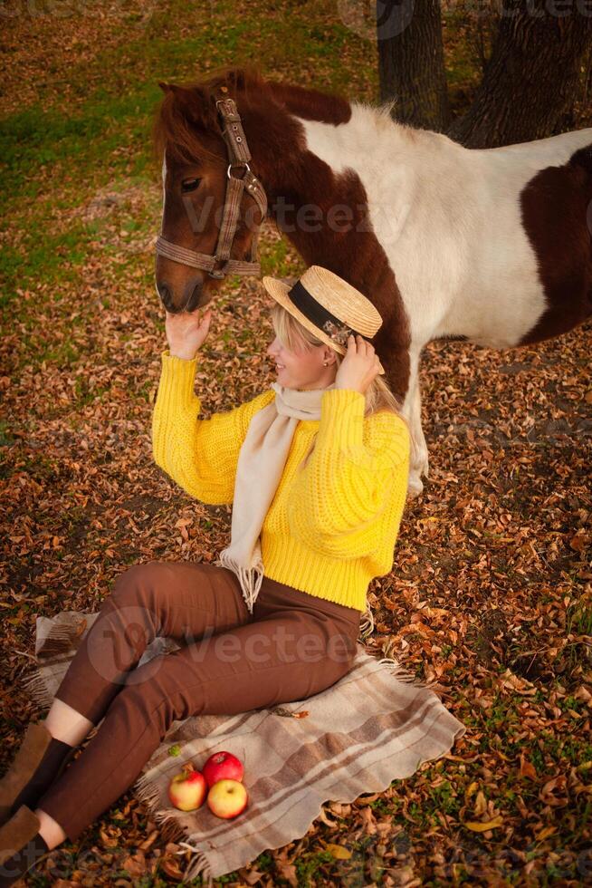 Beautiful picture, autumn nature, woman and horse, concept of love, friendship and care. background. plaid. photo