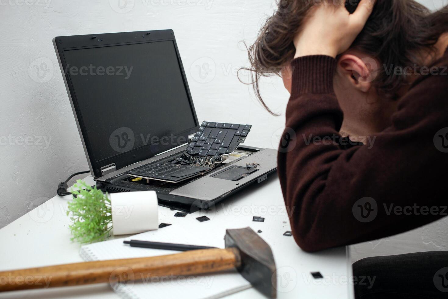 man destroyed laptop with a hammer. Nervous work, buggy computer, errors, slow Internet, not saved in the game, printed text, hung. Bad old computer failed, does not turn on, hangs. Regrets photo