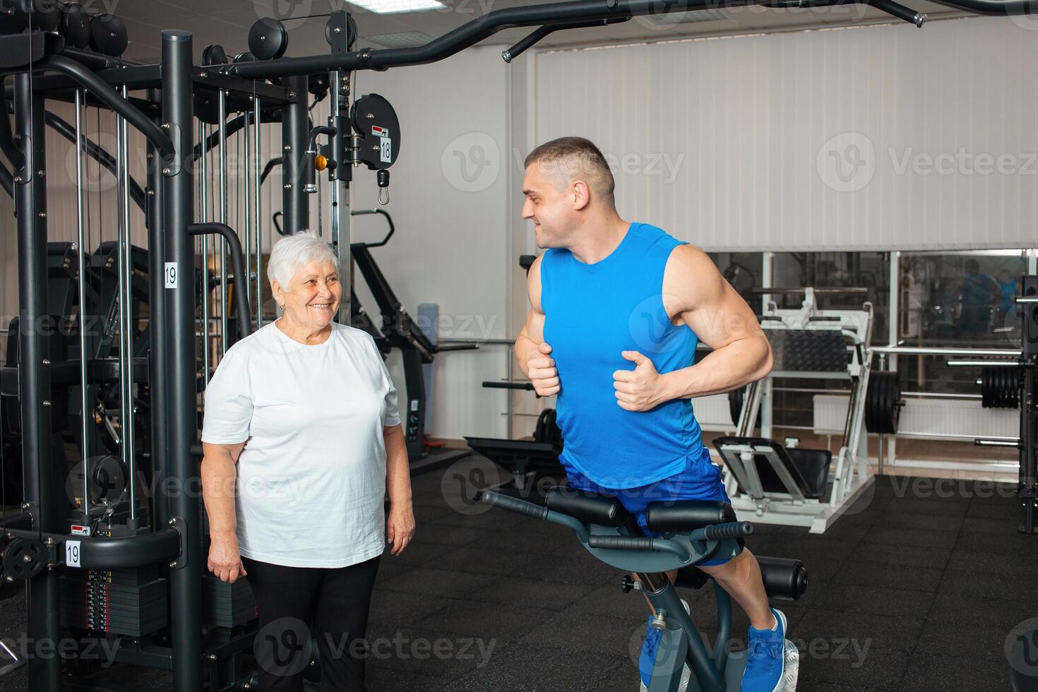 An elderly pensioner plays sports in the gym photo