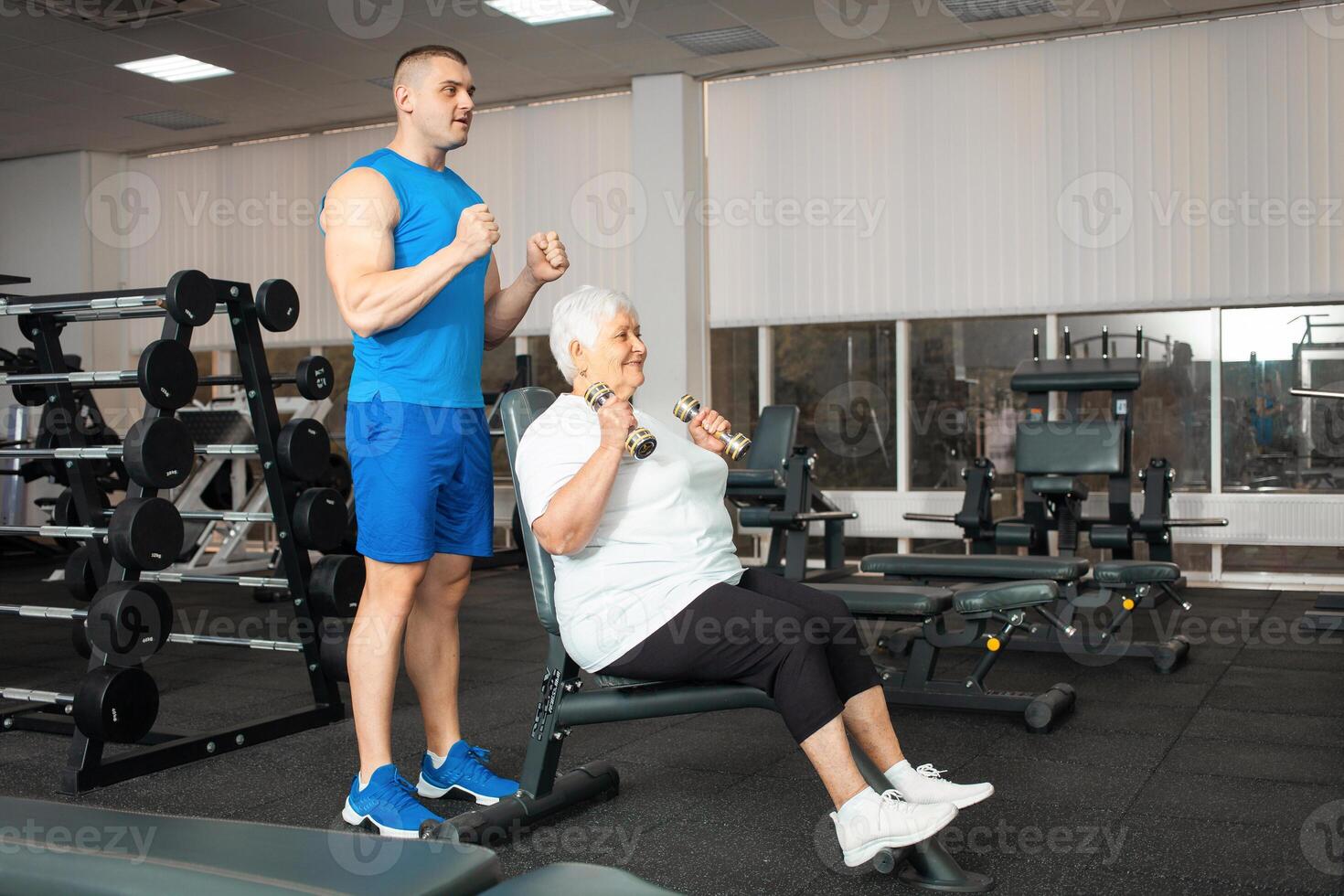 An elderly pensioner plays sports in the gym photo