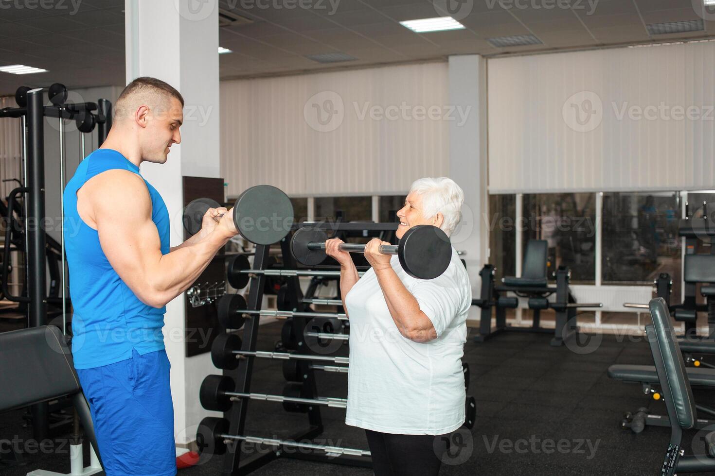 An elderly pensioner plays sports in the gym photo