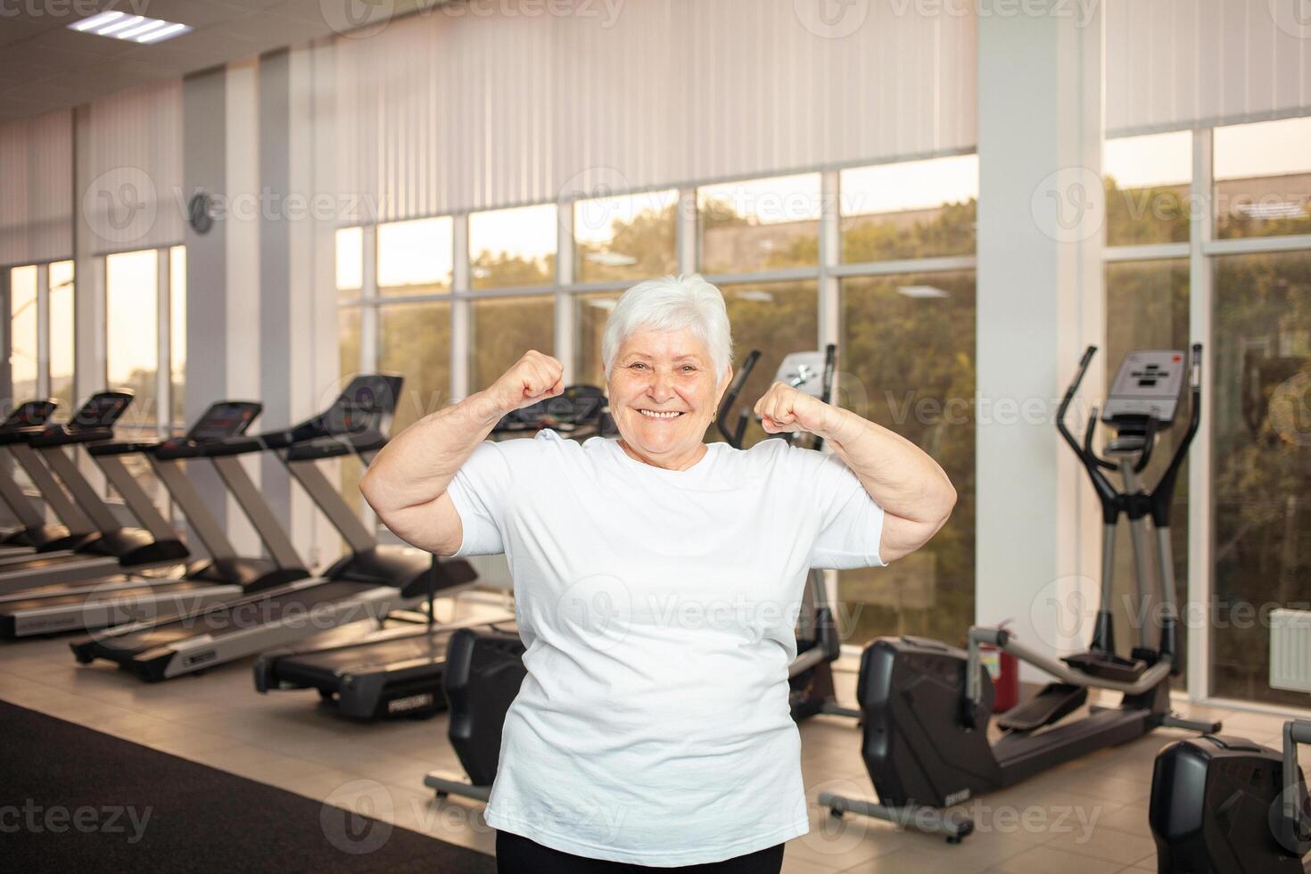 An elderly pensioner plays sports in the gym photo