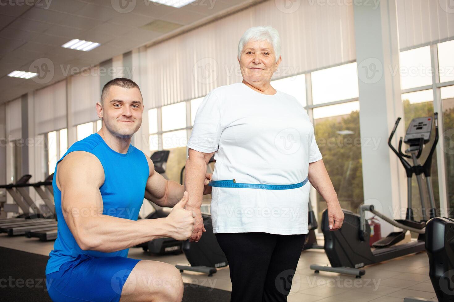 An elderly pensioner plays sports in the gym photo