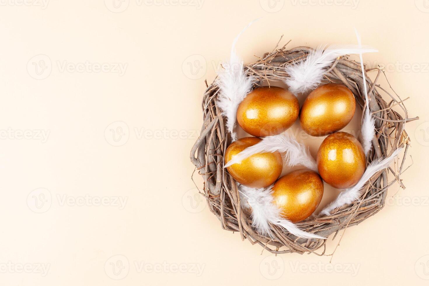 Empty space for text, a banner of happy Easter. Painted golden eggs, feathers. copy space flat lay top view Nest photo