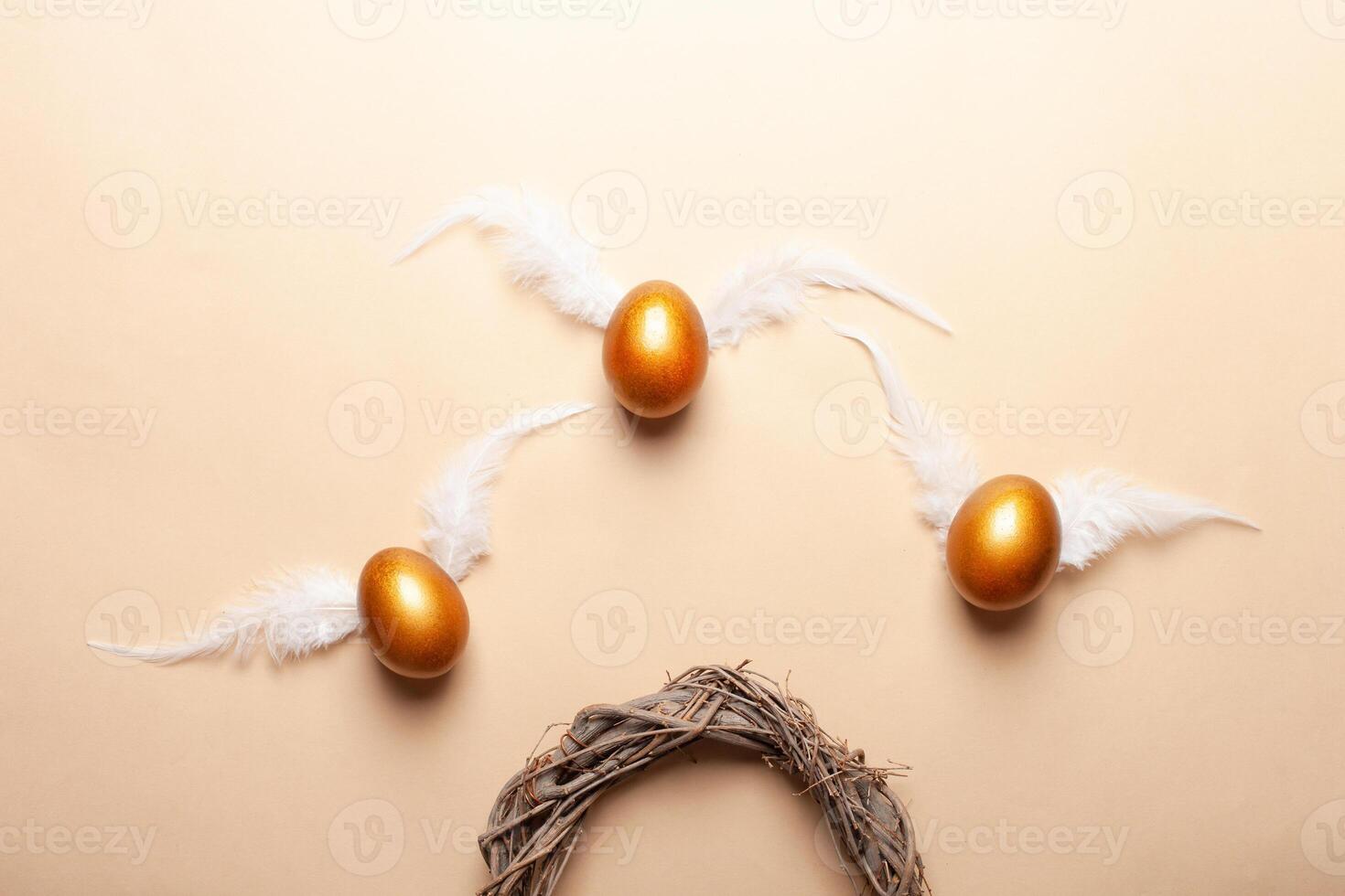 Empty space for text, a banner of happy Easter. Painted golden eggs, white feathers. copy space flat lay top view eggs with wings fly away from the nest photo