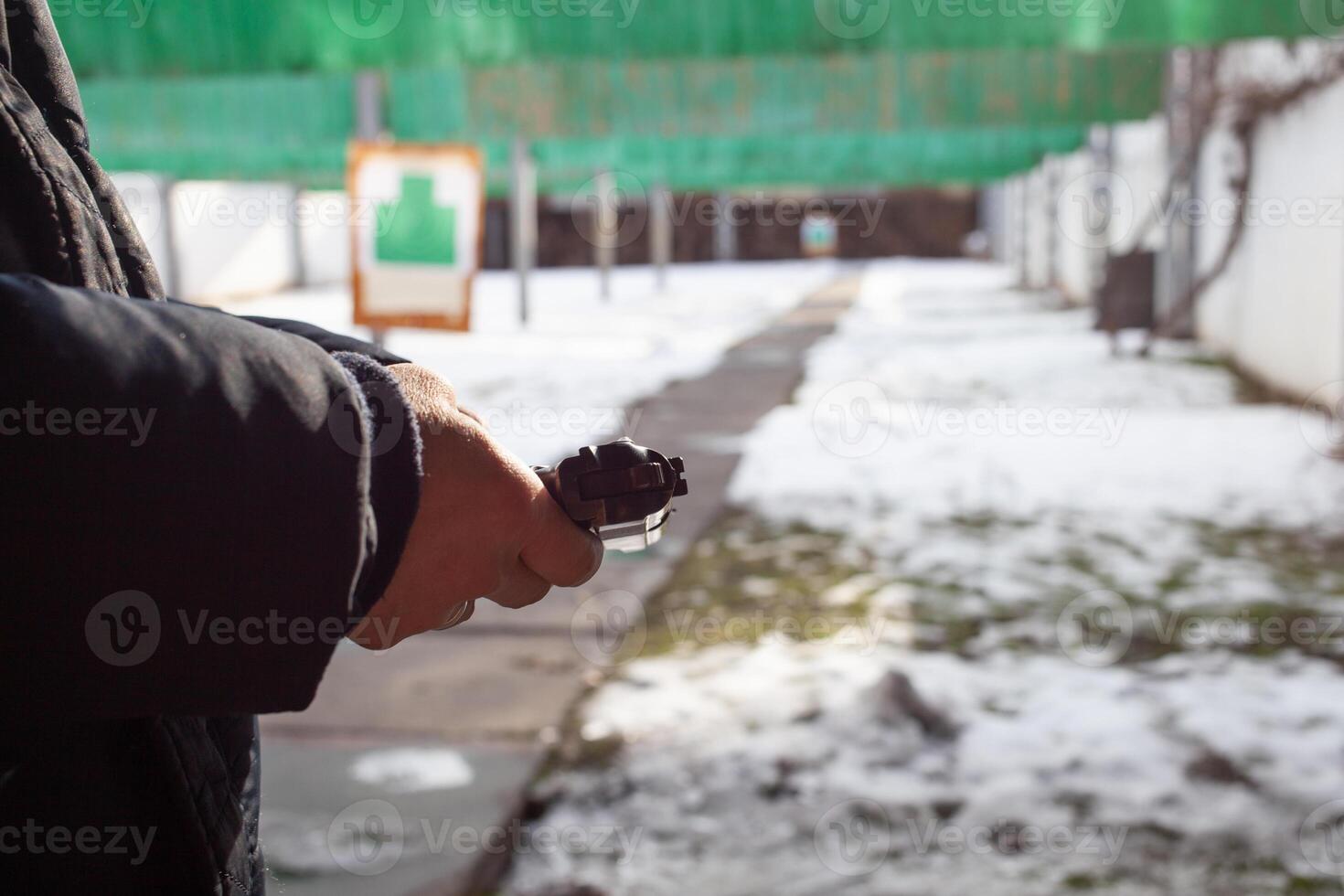 A man reloads a gun. out of the door, shooting range. Murder, danger, firearms. snow on the ground photo