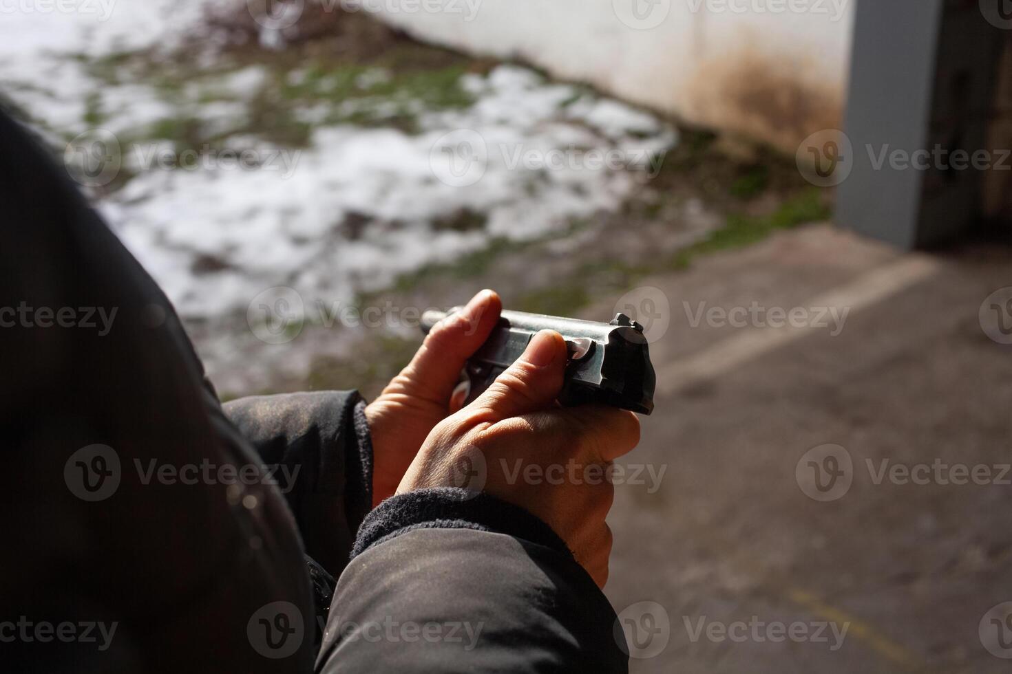 A man reloads a gun. out of the door, shooting range. Murder, danger, firearms. photo