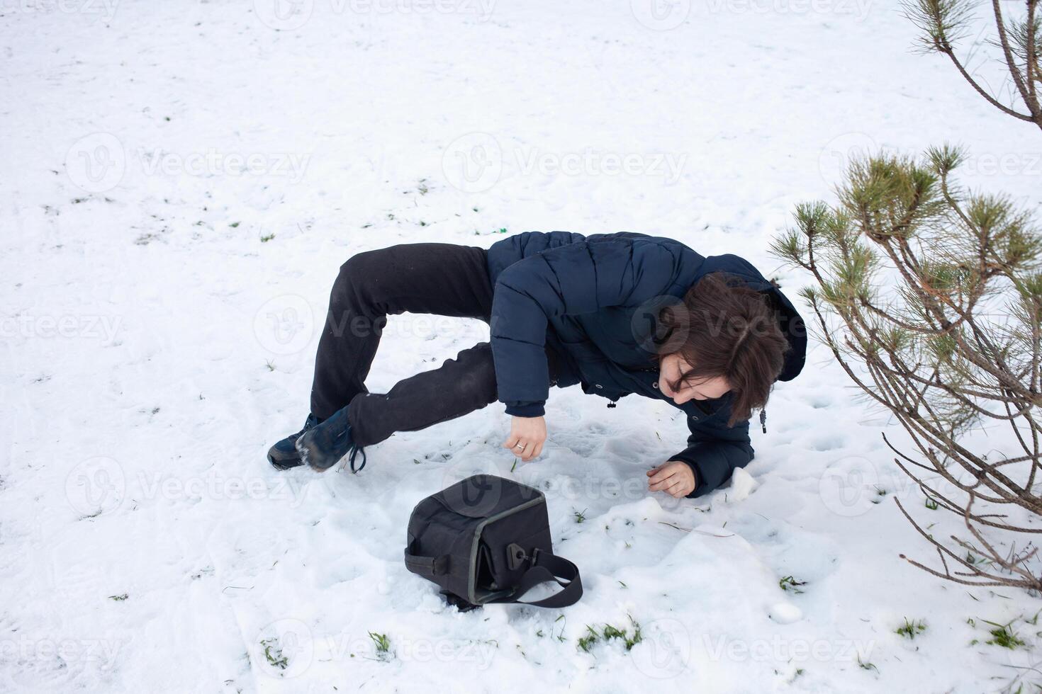 un hombre caídas en el nieve. el hombre resbaló y estaba herido. que cae en hielo. invierno. fractura, moretón, dislocación. foto