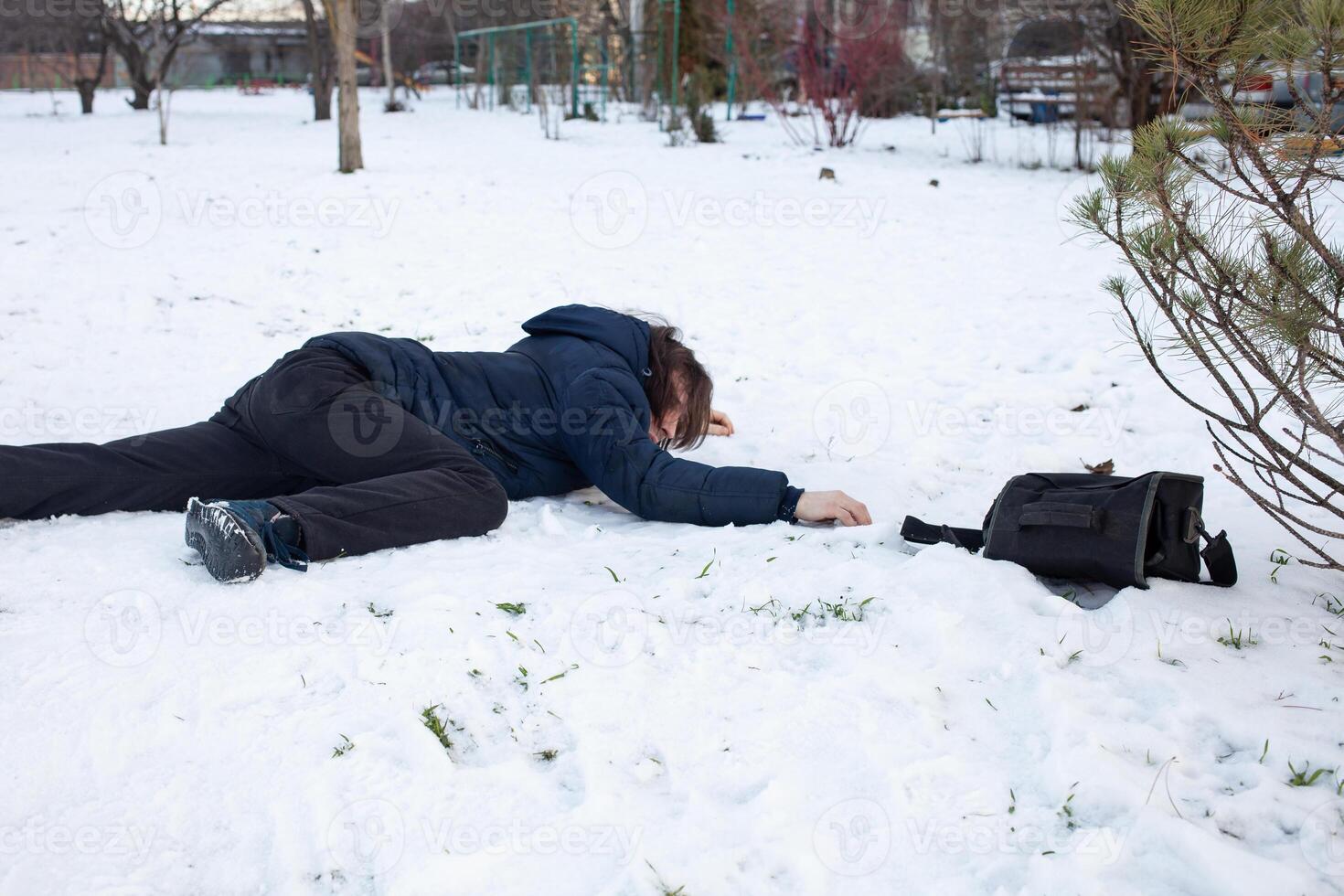 A man falls in the snow. The man slipped and was injured. Falling on ice. Winter. Fracture, bruise, dislocation. photo