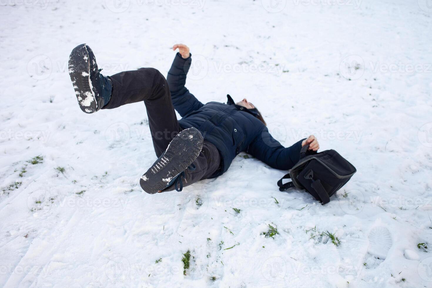 A man falls in the snow. The man slipped and was injured. Falling on ice. Winter. Fracture, bruise, dislocation. photo