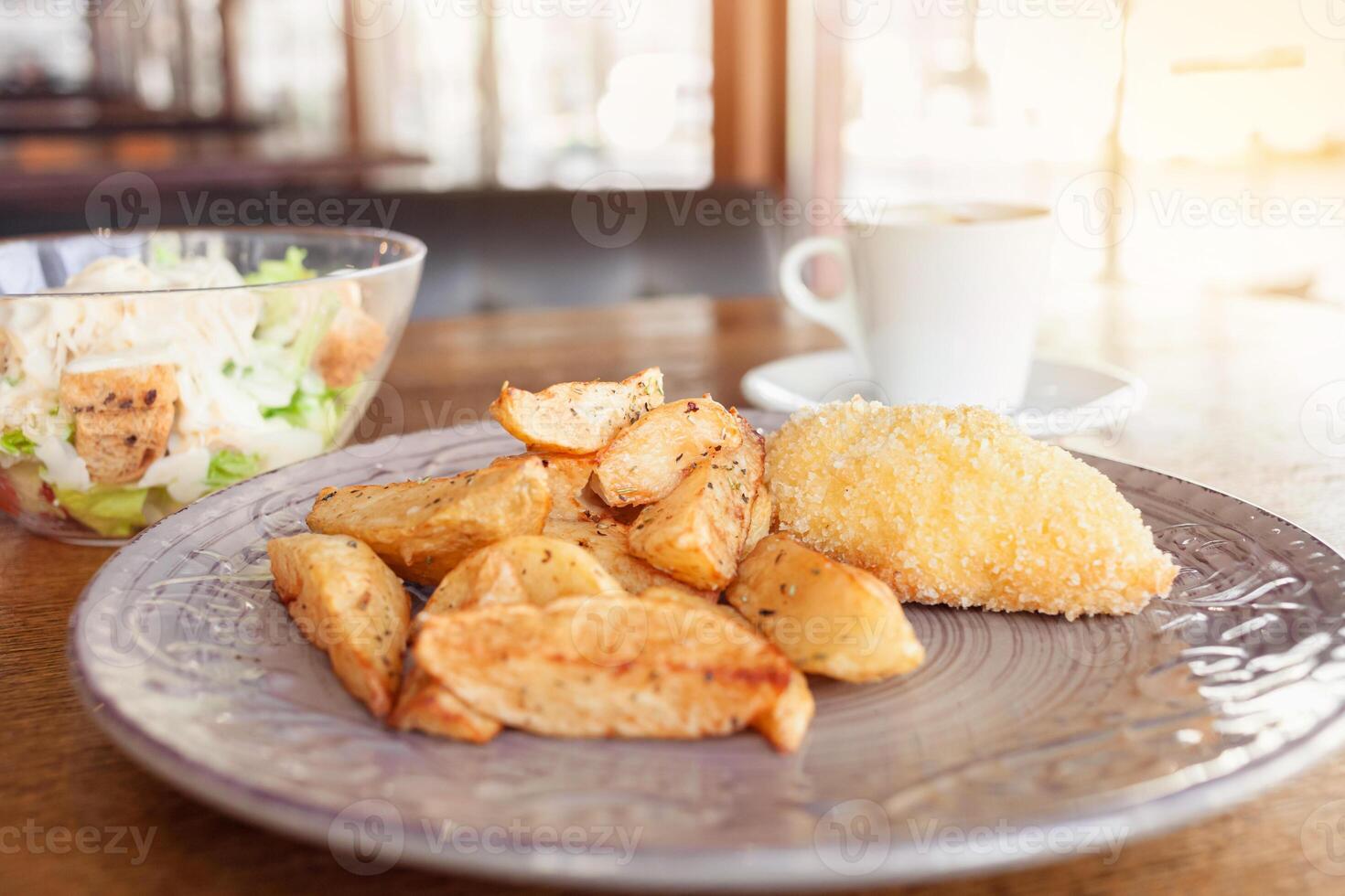 Breakfast, dinner, lunch in a restaurant, cafe. Baked potatoes with meatballs, caesar salad, Coffee Americano. intervier, delicious food, large windows, natural sunlight. Blurred background photo