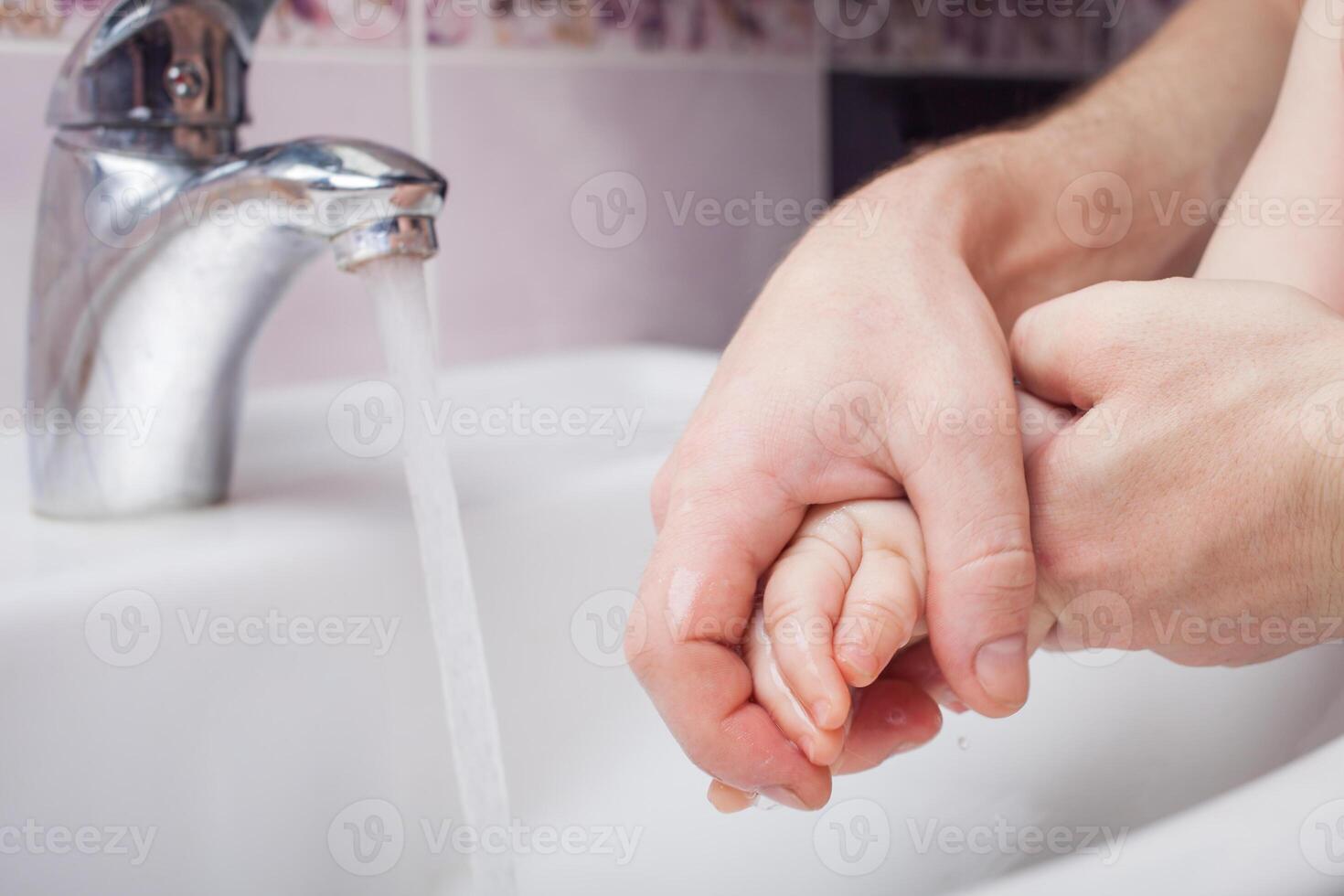 child washes hands in sink. jet of water from tap. Disinfection of hands with water. photo