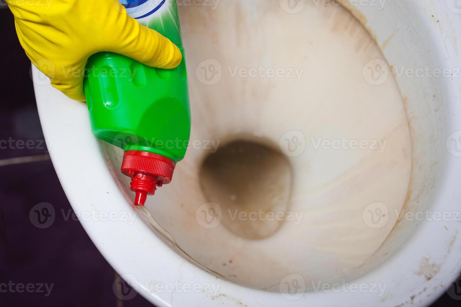 Maid with rubber glove cleaning tap and sink. photo