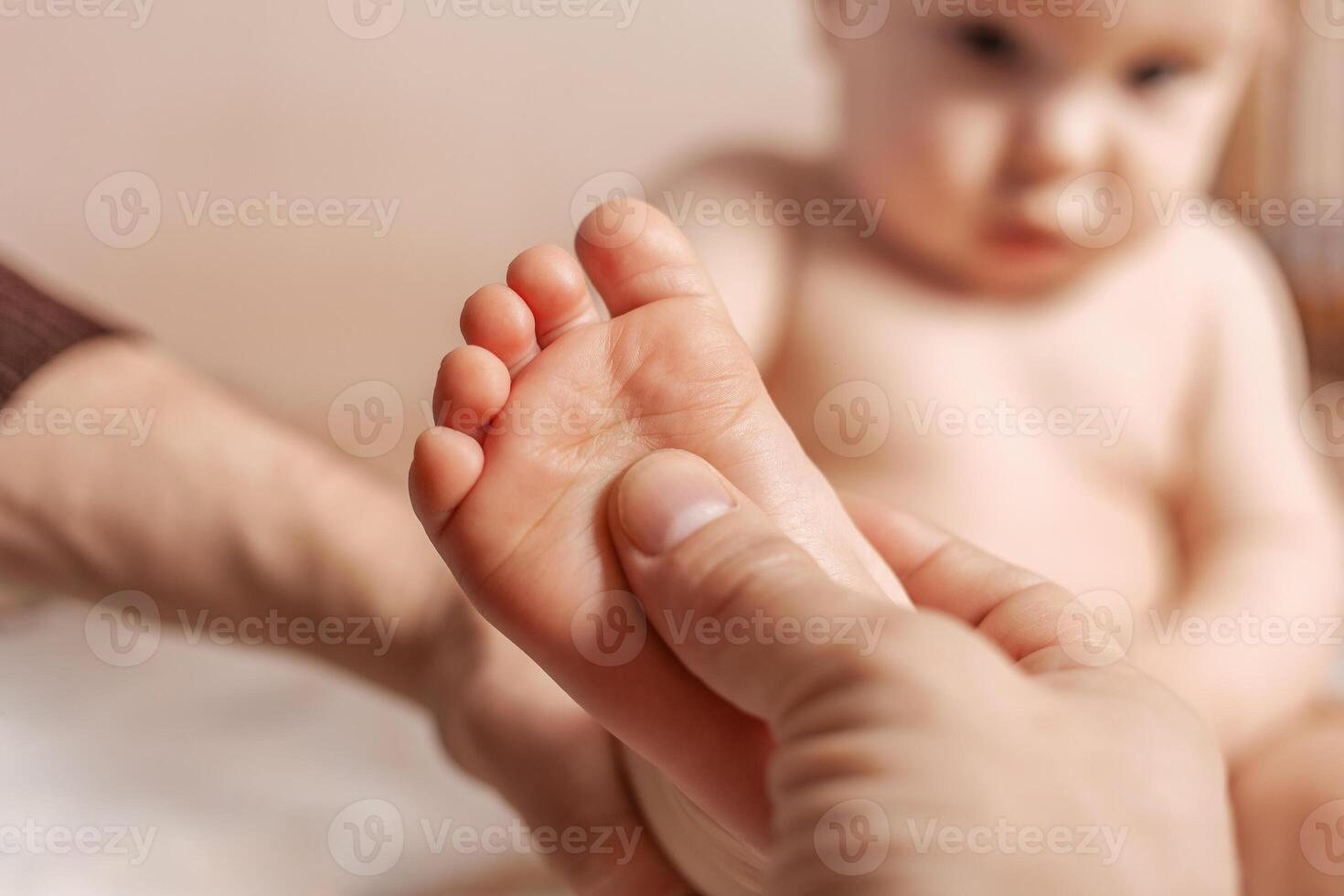 Massage. Little baby having a massage from his mother with a big pleasure photo