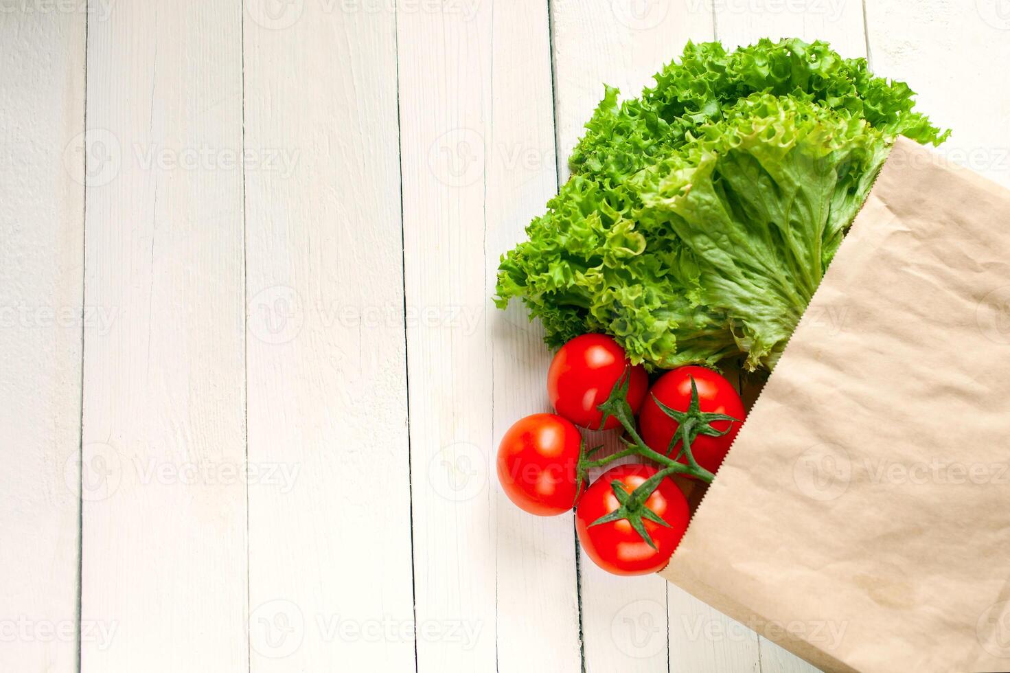 Paper bag on a wooden background, vegetables from the store photo